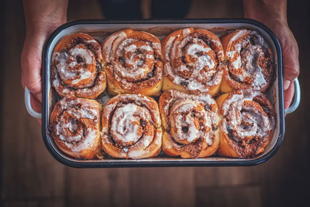 A tray of freshly iced cinnamon scrolls lifted from the oven