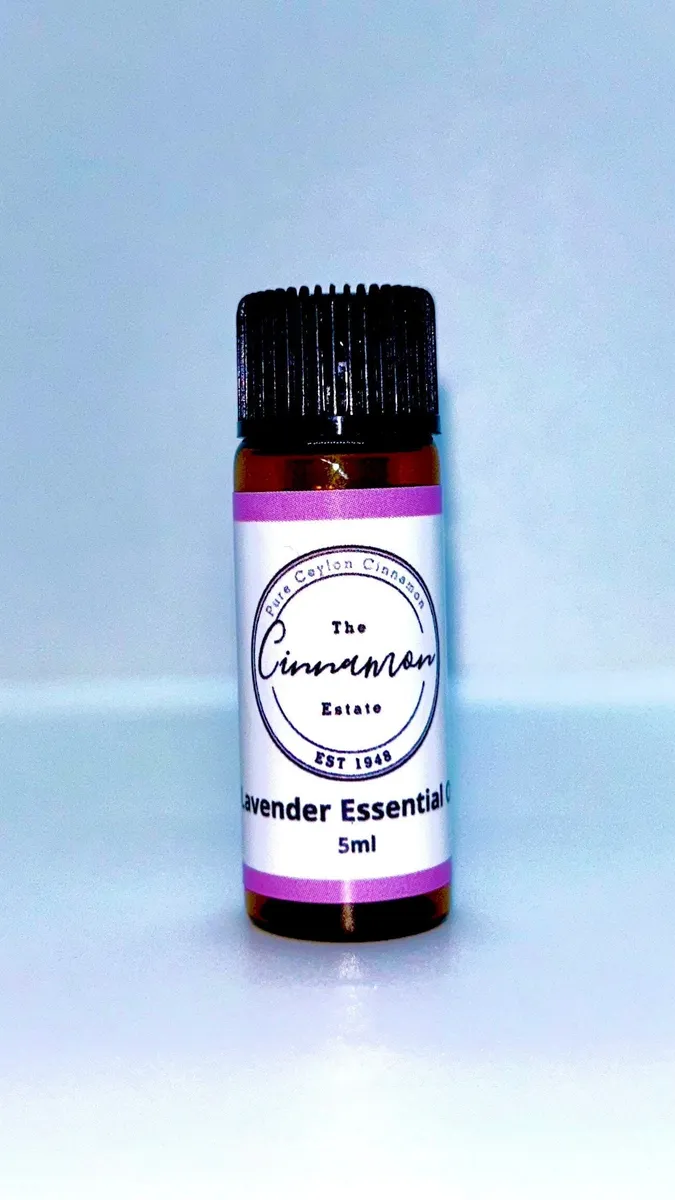 An amber dropper bottle of The Cinnamon Estate pure lavender essential oil, with a lilac striped label.