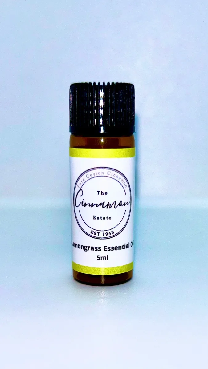 An amber dropper bottle of The Cinnamon Estate lemongrass essential oil, with a chartreuse striped label.